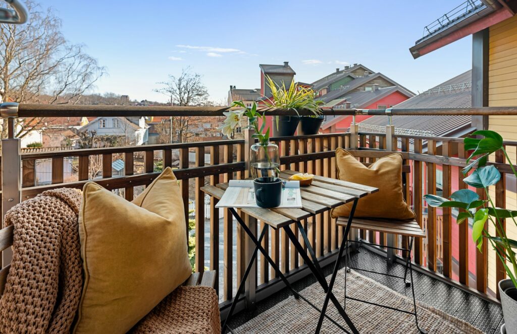 Petit balcon meublé avec table, chaises et plante en pot