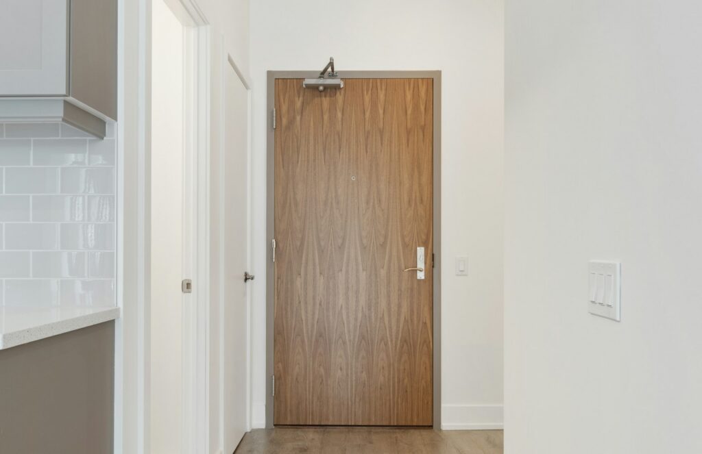 Porte en bois et couloir lumineux dans une entrée résidentielle
